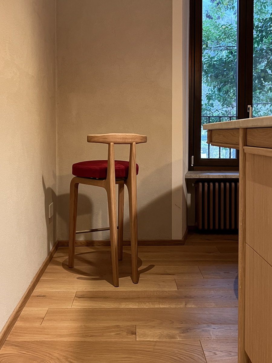 Dettaglio sgabello disegnato su misura accostato all’isola