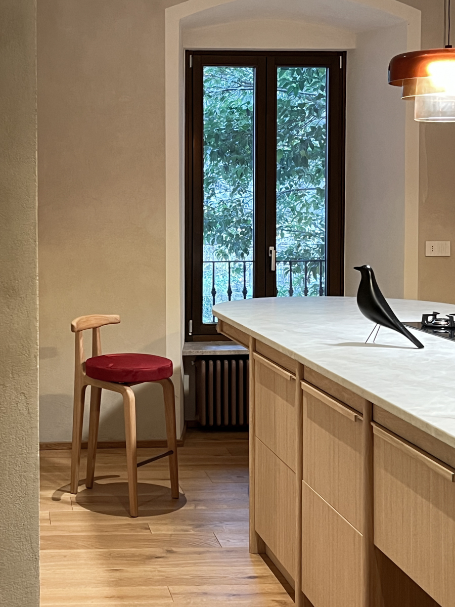 Rapporto tra isola, luce sospesa e pareti a calce naturale