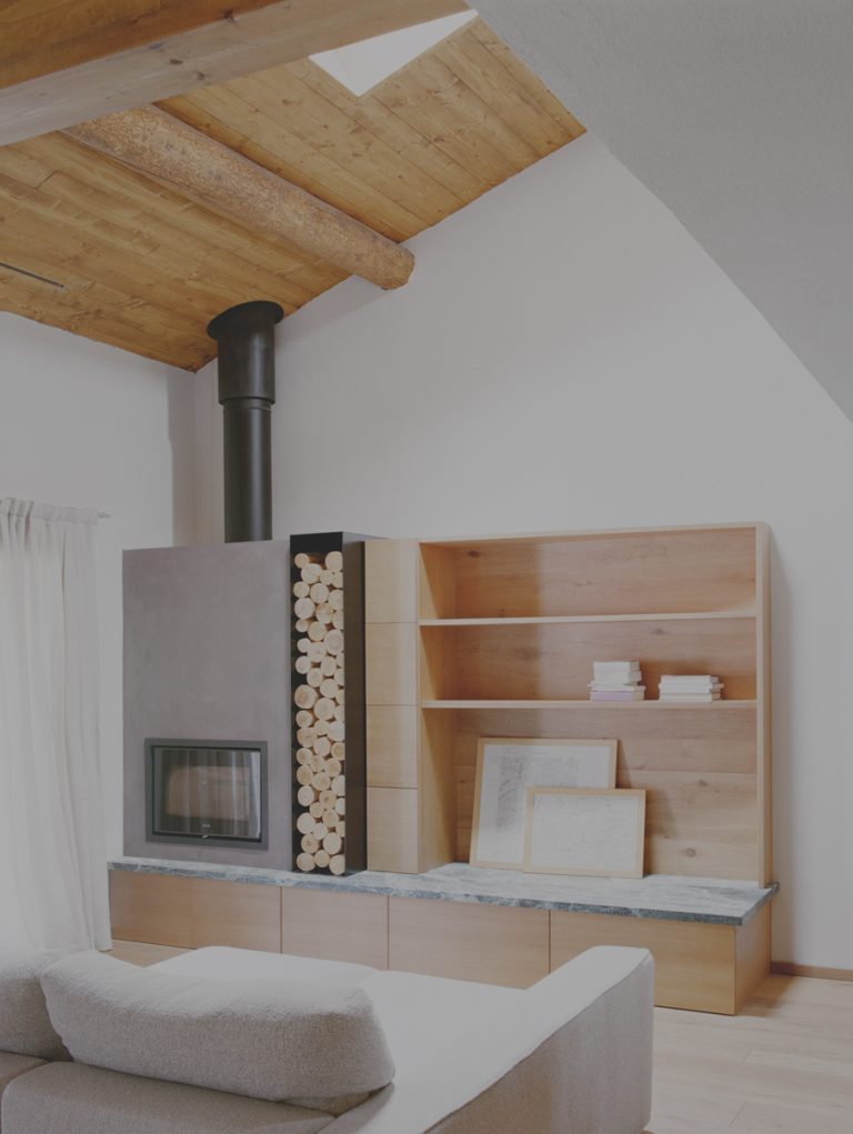 Soggiorno con camino integrato e arredi in legno su misura con marmo di Gressoney