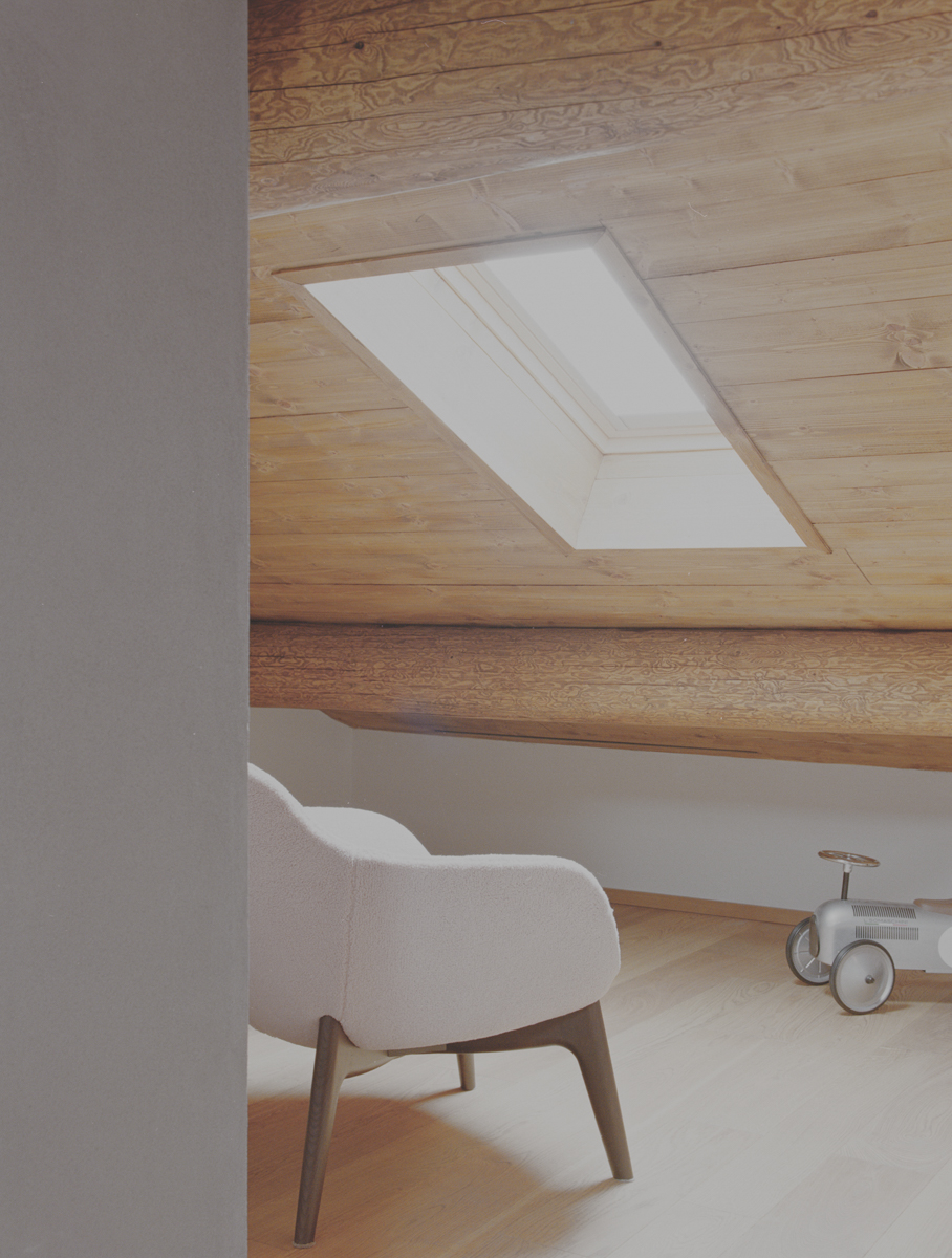 Dettaglio del sottotetto in legno con lucernario naturale nella ristrutturazione di un appartamento a Champorcher