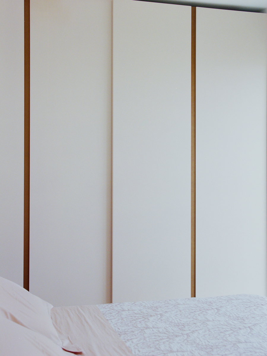 Camera da letto dell’attico con armadiature su misura e palette cromatica chiara