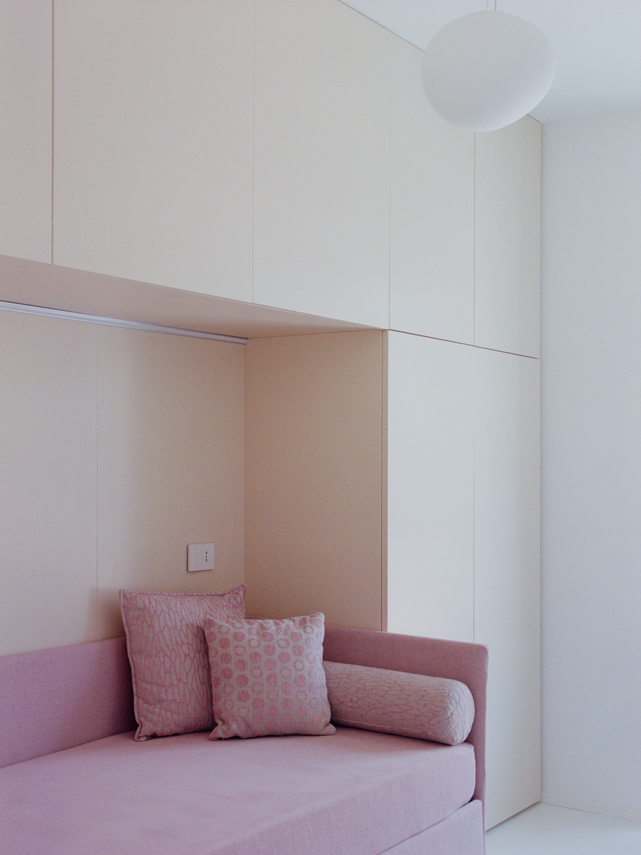 Camera da letto con armadi su misura e continuità cromatica con la zona giorno